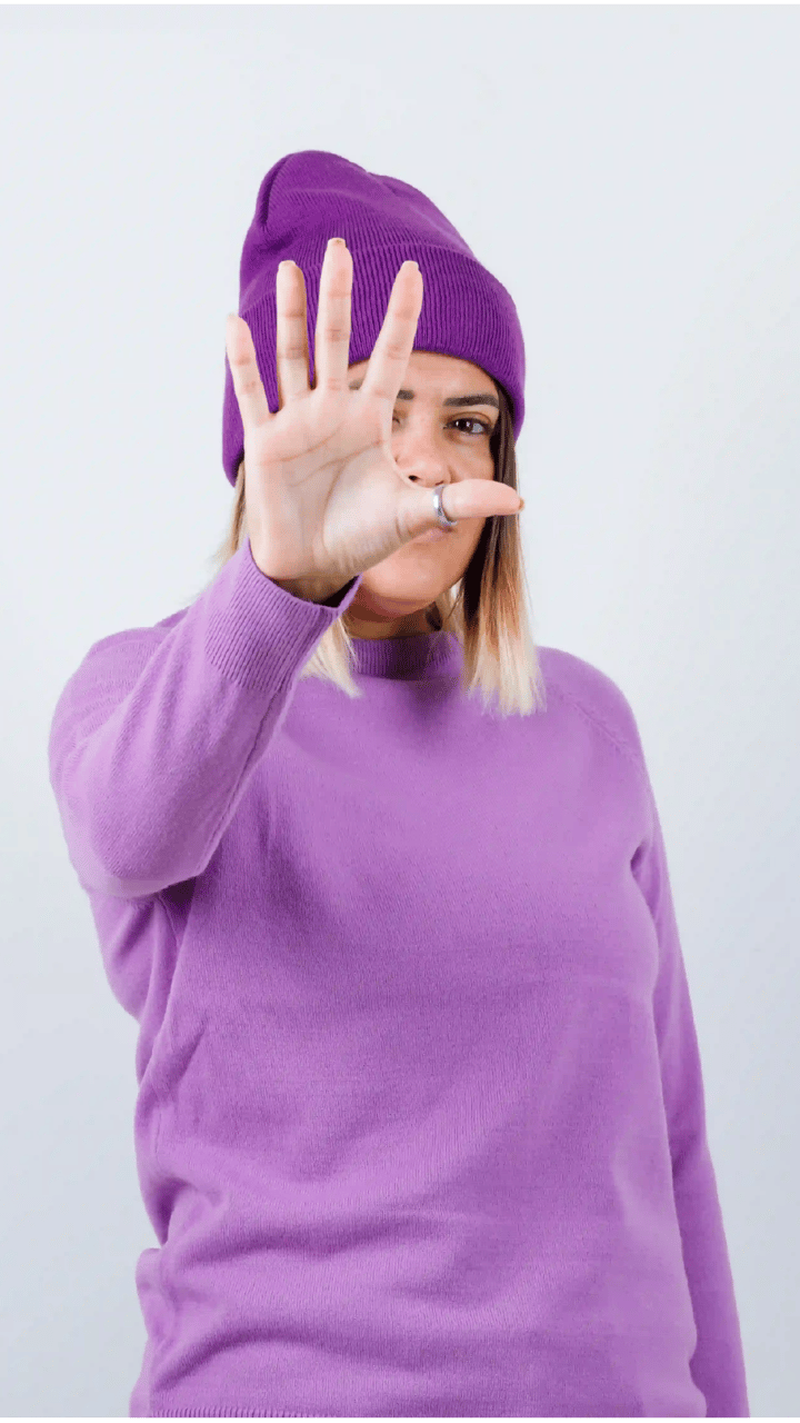 cute-woman-showing-stop-gesture-sweater-beanie-looking-resolute-front-view-01