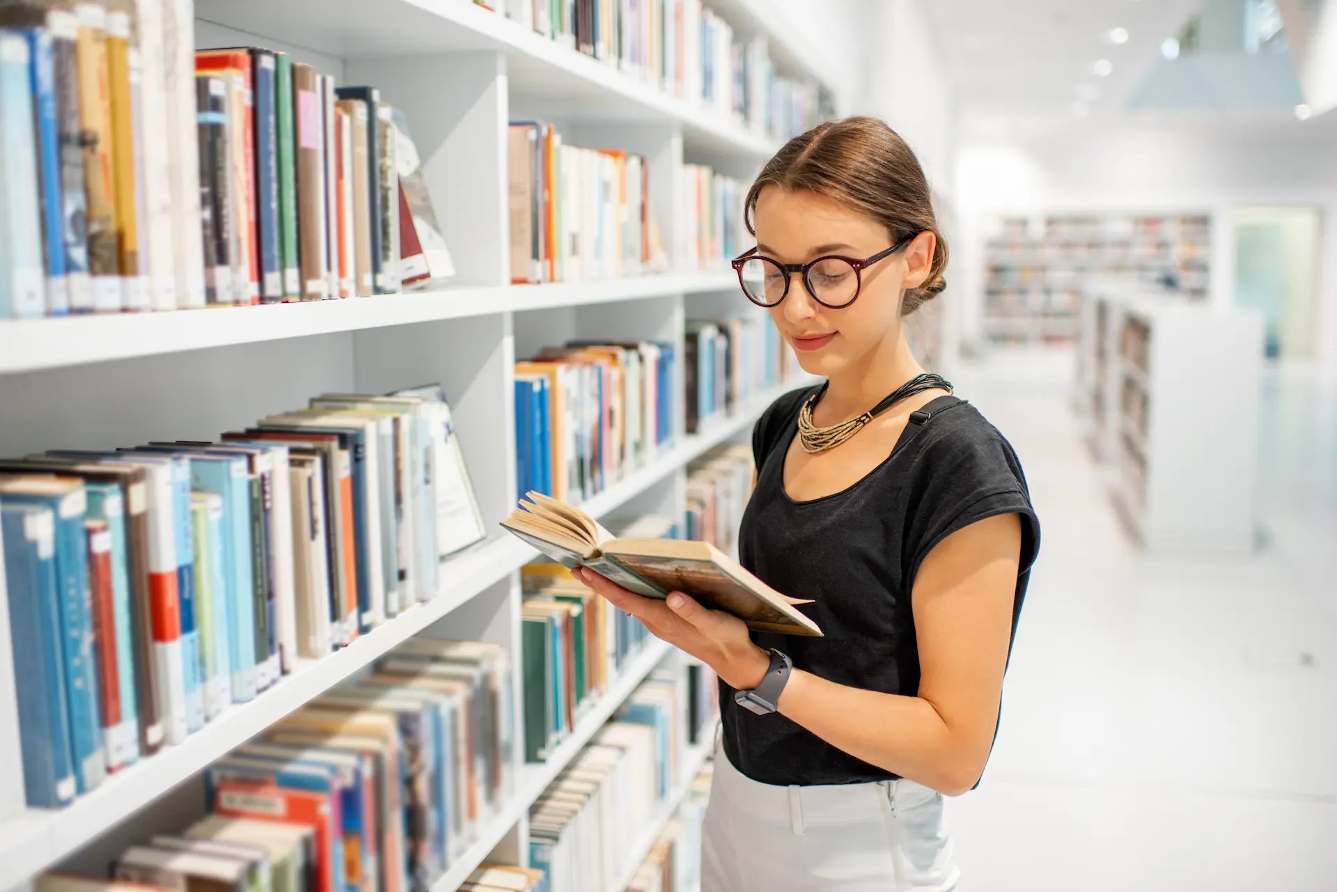 Mujer leyendo un libro en la biblioteca