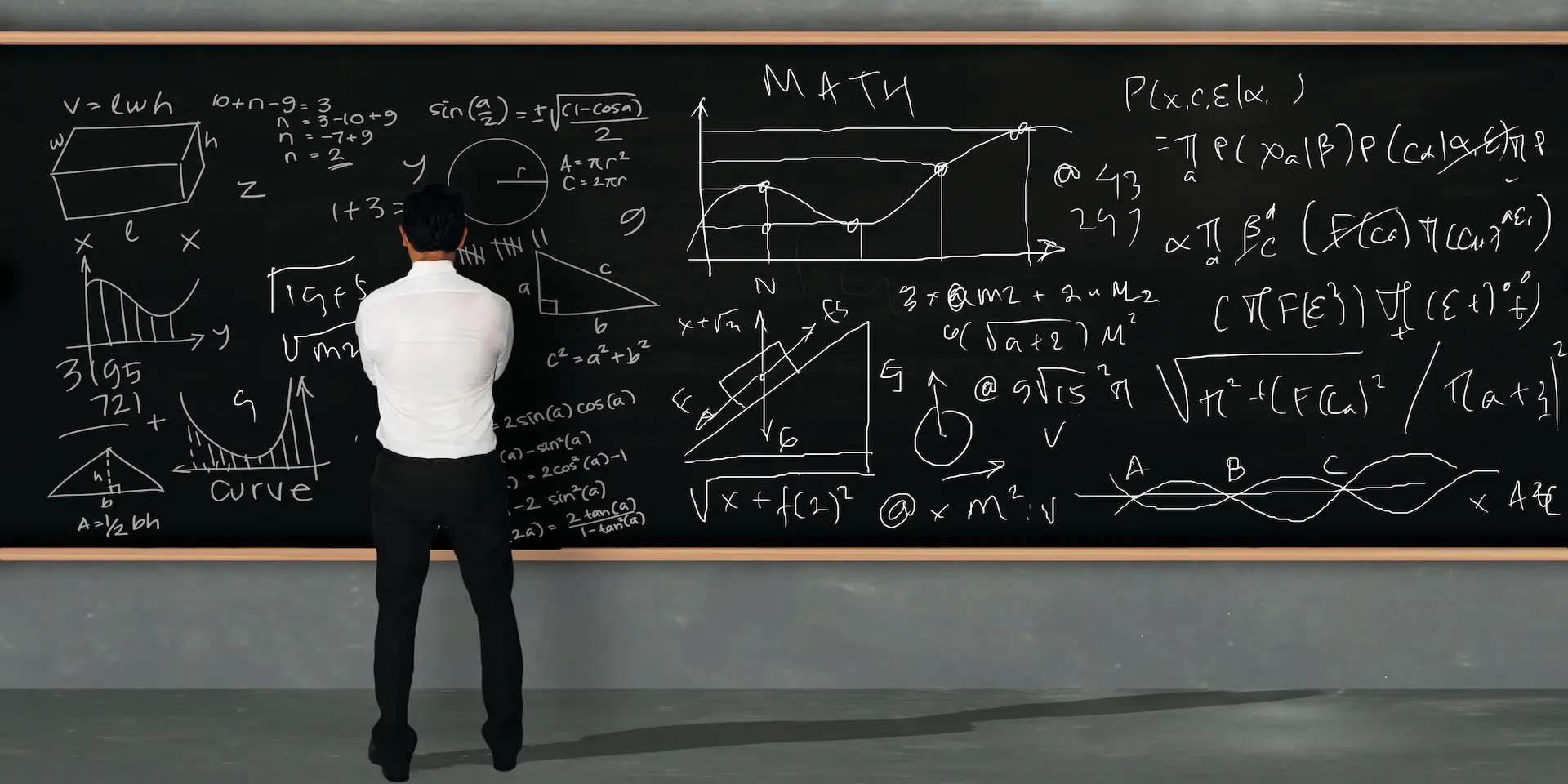 Hombre en frente de un tablero con problemas matemáticos