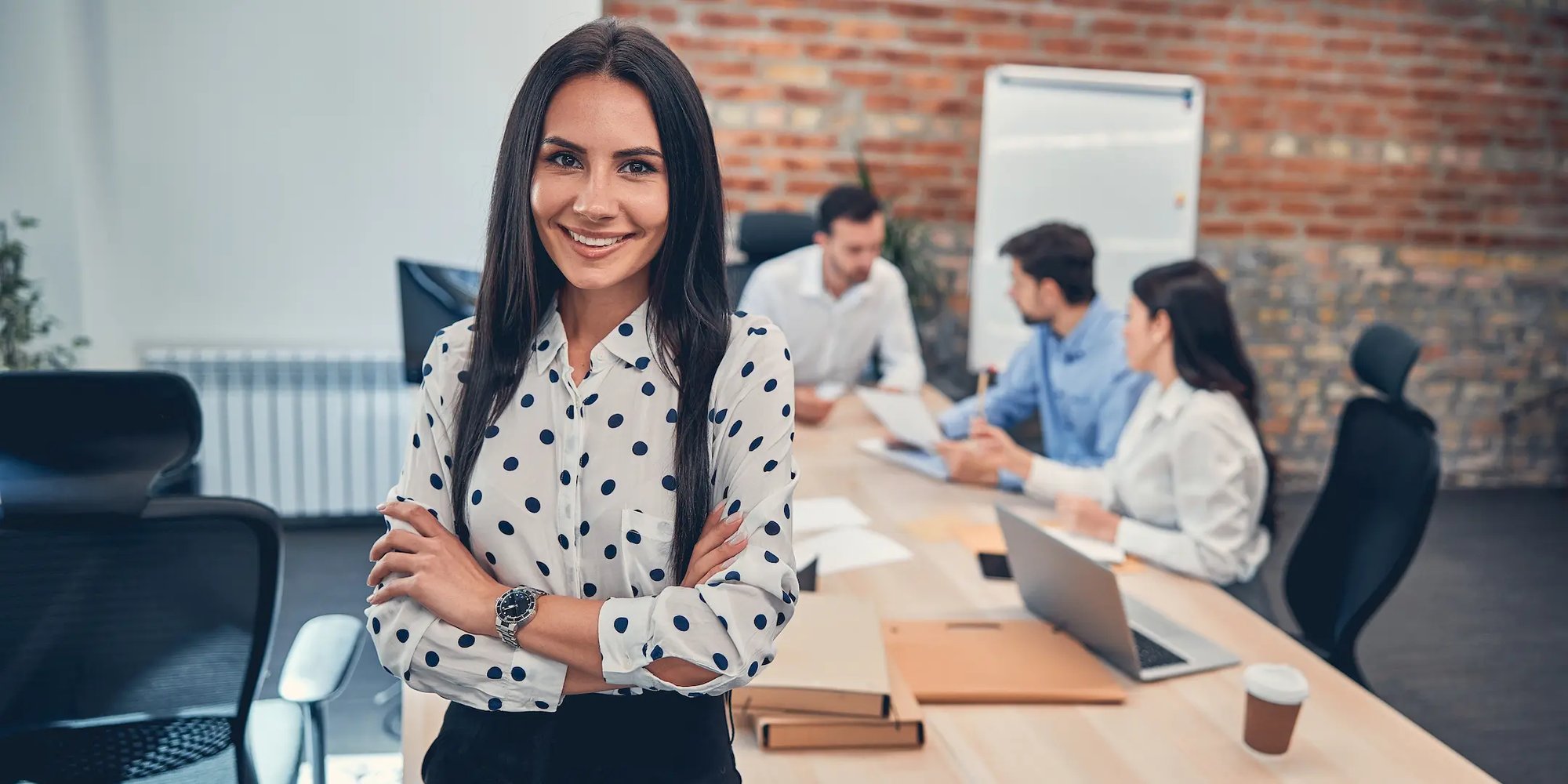 Mujer sonriendo con su equipo de trabajo