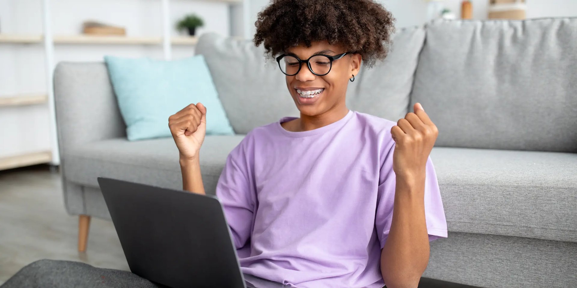 Joven feliz mirando su computadora